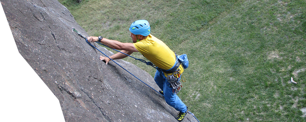 grimpeur mettant une dégaine à dorénaz en valais lors d'un cours d'escalade donné par lionel bonvin